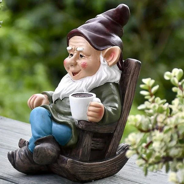 A charming garden gnome ornament made of durable resin, sitting in a rocking chair and sipping tea, adding whimsical personality to an outdoor space