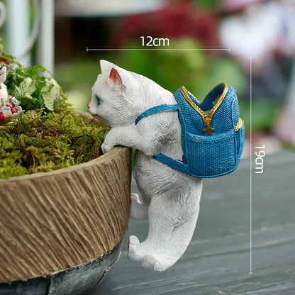 A charming resin cat figurine wearing a stylish backpack, serving as a unique garden decoration and practical storage solution.