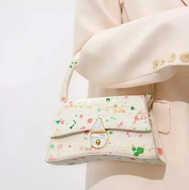 A stylish half-moon shaped genuine leather handbag with a decorative lock, showcasing premium British craftsmanship and timeless elegance.