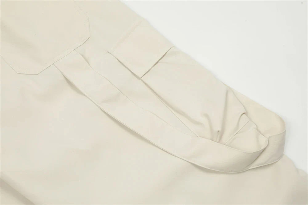 Stylish black pleated overalls with ribbon pockets, a versatile and refined menswear piece.