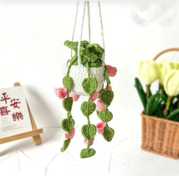 Charming knitted car plant decor with hanging white rope and green and white colour scheme