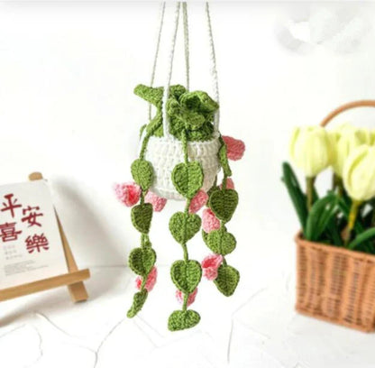 Charming knitted car plant decor with hanging white rope and green and white colour scheme