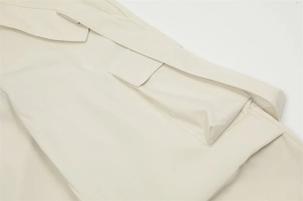 Stylish black pleated overalls with ribbon pockets, a versatile and refined menswear piece.