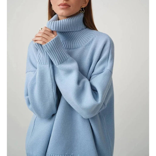Cosy oversized knitted pullover in blue, featuring a classic turtleneck collar and drop-shoulder silhouette for maximum comfort and style.
