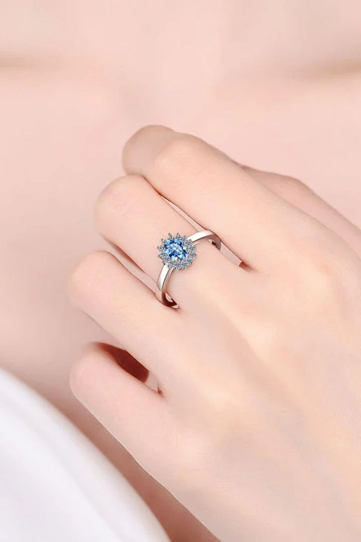 A close-up of a minimalist, polished 925 sterling silver ring with a dazzling moissanite centre stone