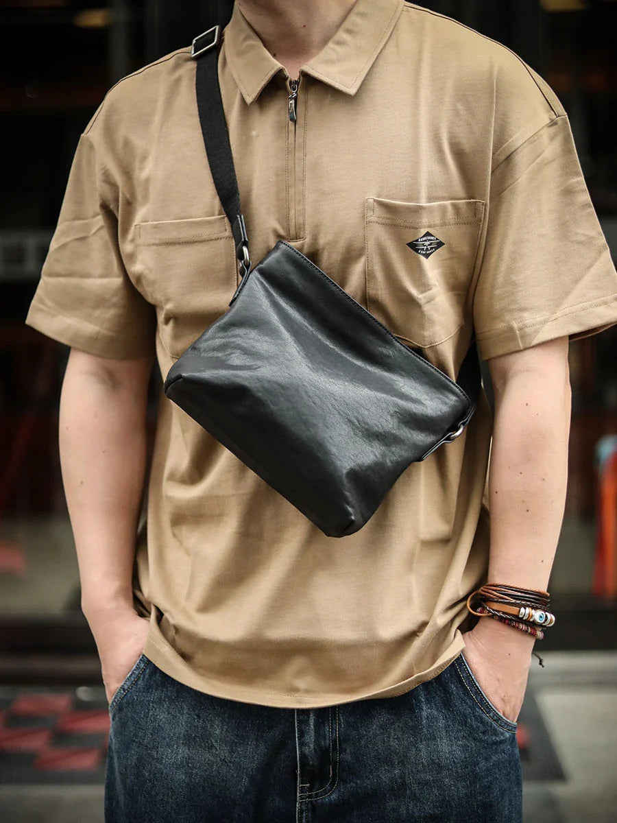 Premium black leather shoulder bag with horizontal zipper closure, featuring a spacious interior and versatile design for the modern British gentleman