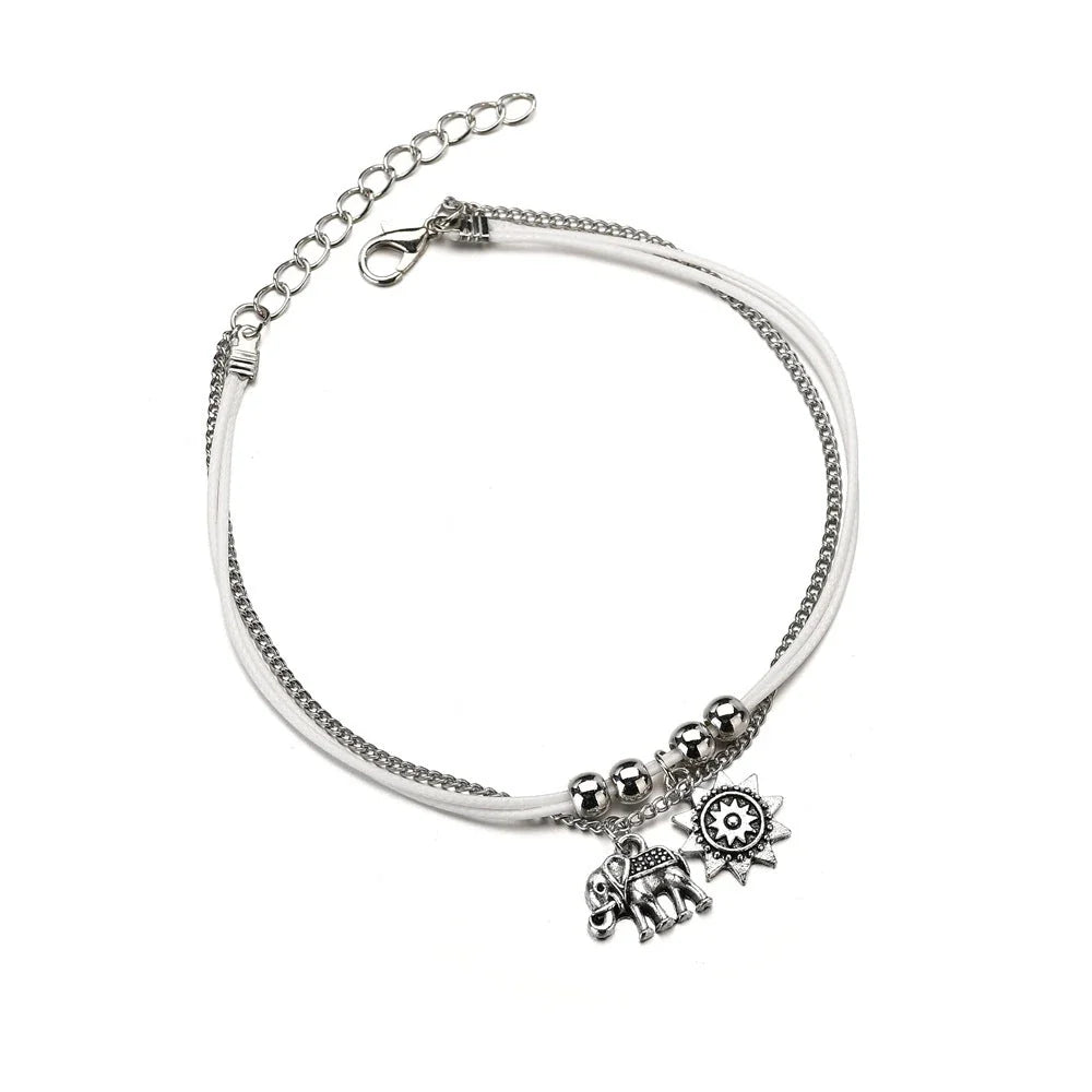 Elegant bohemian-style anklet with star and elephant charms in shimmering gold and silver tones