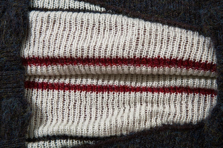 A cosy and stylish jumper featuring a patchwork design with contrasting stripes in a classic British colour palette.