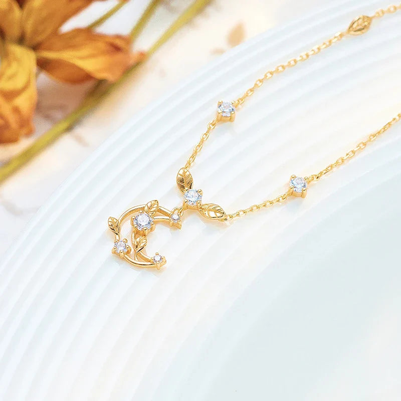 Elegant crescent moon necklace with intricate leaf design in a gleaming gold tone