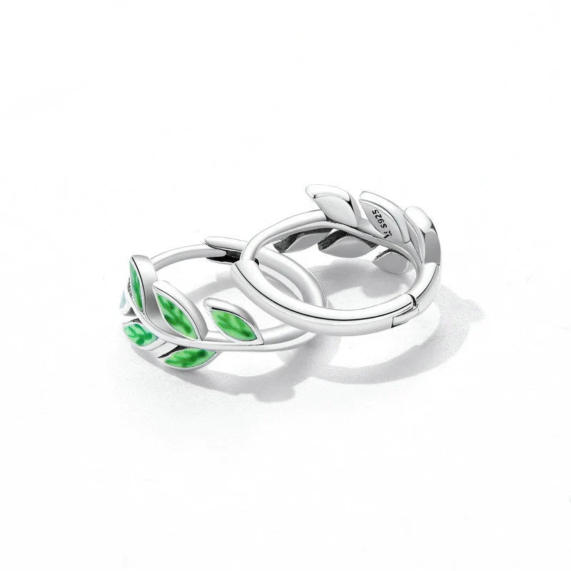 Elegant silver earrings with a fern-inspired design and sparkling green zircon centerpiece