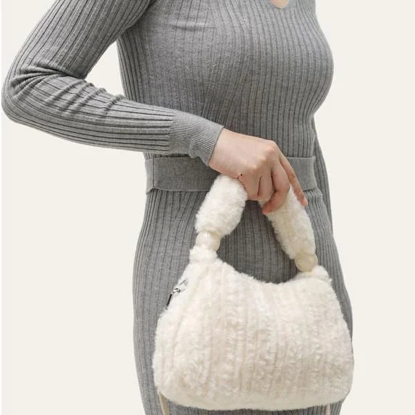 A luxurious faux fur hobo handbag with a stylish baguette shape and secure zipper closure