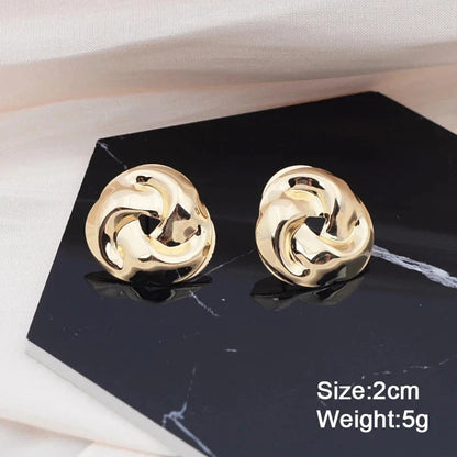 Pair of gold spiral drop earrings with an exaggerated, dramatic design for a bold, fashionable look