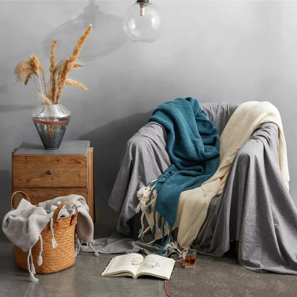 Luxurious Nordic-style wool knitted throw blanket in grey colour, featuring a solid pattern and elegant tassel design