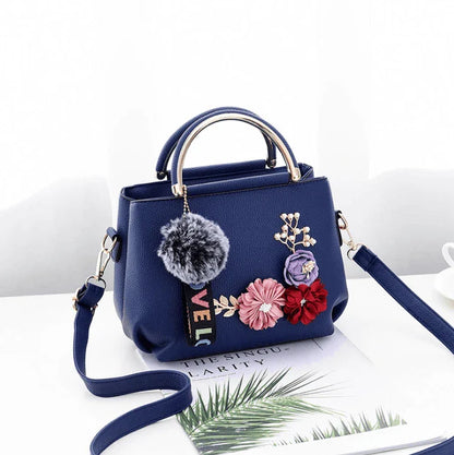 Elegant leather tote bag with delicate flower embellishments, perfect for modern British fashion