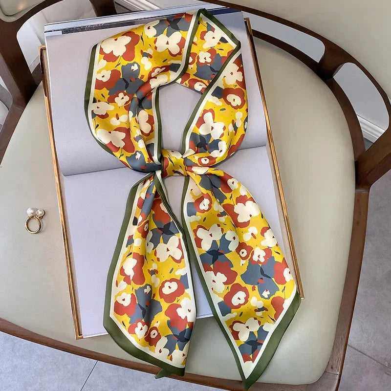 A vibrant floral-patterned silk-feel long scarf that can be worn as a neck accessory, hair tie, or wrist adornment for all occasions.
