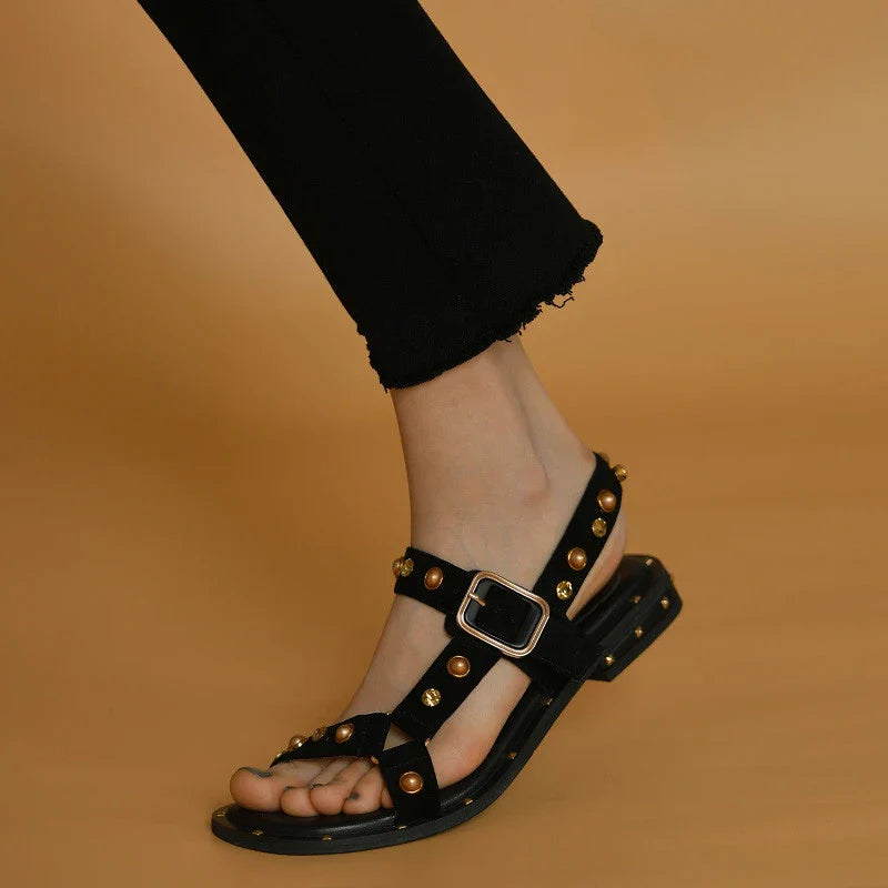 Black flat sandals with orange accents, inspired by the Roman Holiday style, suitable for women