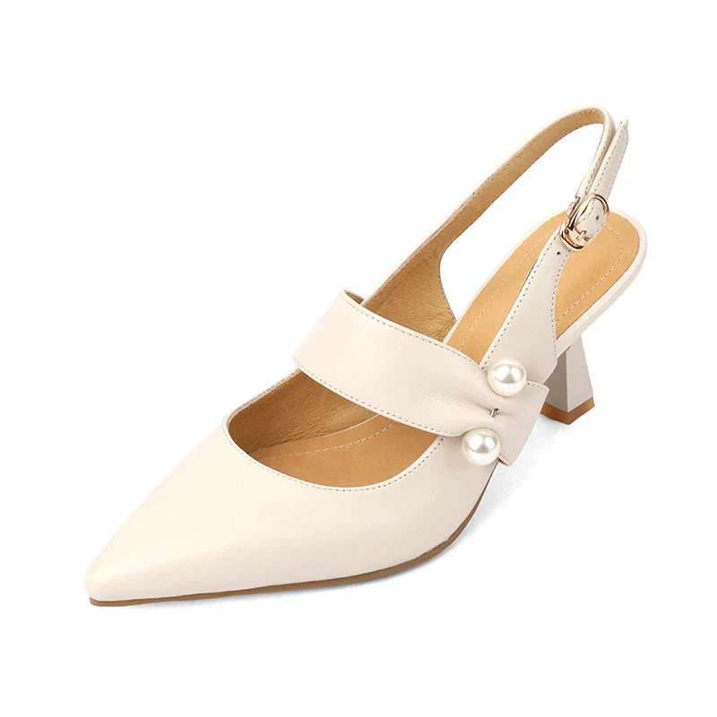 Pair of white high heel sandals with pearl embellishments, showcasing a unique and fashionable design