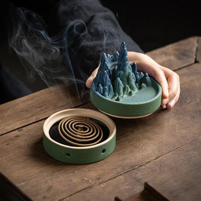 Elegant ceramic incense burner with a tranquil mountain and river design, creating a serene visual display