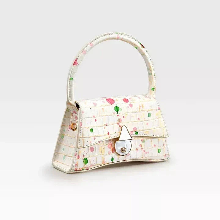 A stylish half-moon shaped genuine leather handbag with a decorative lock, showcasing premium British craftsmanship and timeless elegance.