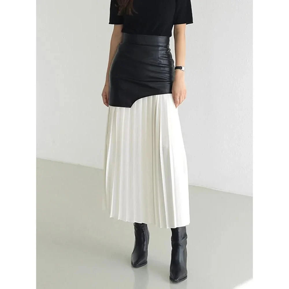 A stylish long pleated skirt featuring a sophisticated leather patchwork design and a flattering A-line silhouette
