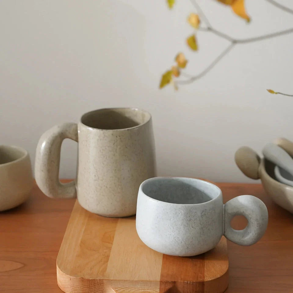 Handcrafted Japanese ceramic retro coffee mug in solid apricot or grey colour, featuring a comfortable handgrip design for enhanced daily beverage enjoyment.