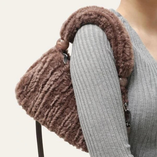 A luxurious faux fur hobo handbag with a stylish baguette shape and secure zipper closure
