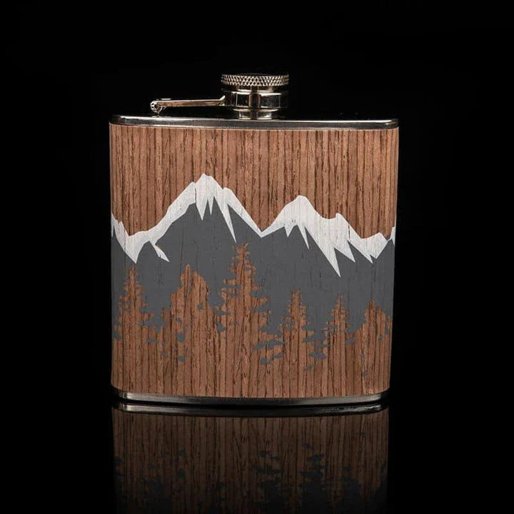 Stylish mountain-themed stainless steel and wood hip flask with optional glasses, perfect for outdoor adventures and social gatherings.