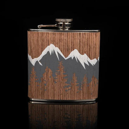 Stylish mountain-themed stainless steel and wood hip flask with optional glasses, perfect for outdoor adventures and social gatherings.