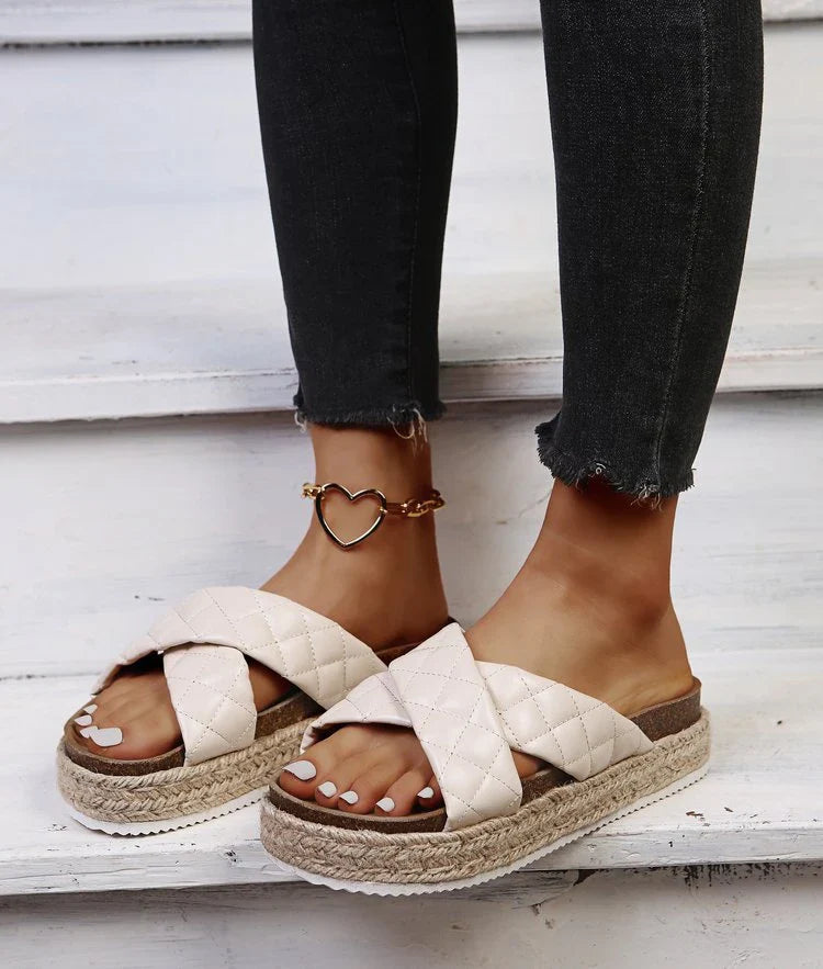 Elegant cross-toe platform sandals and slippers in a neutral creamy white hue, showcasing a contemporary and refined design for the discerning woman