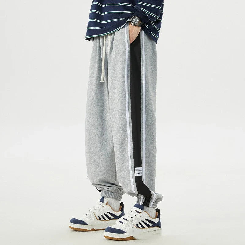 Plus-size men's loose sports trousers with ankle ties, made of premium polyester fabric in classic colours for versatile, comfortable activewear.