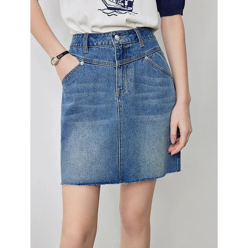 Sophisticated lyocell denim mini skirt with classic A-line silhouette and functional pockets for the discerning British woman