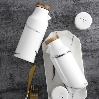 Ceramic salt and pepper shaker set with oil bottle in light grey porcelain finish, featuring minimalist design and easy-grip handles