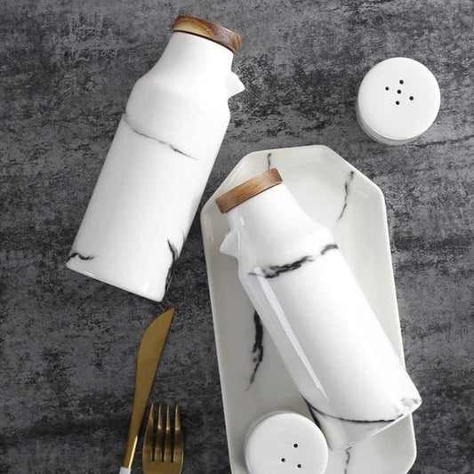 Ceramic salt and pepper shaker set with oil bottle in light grey porcelain finish, featuring minimalist design and easy-grip handles