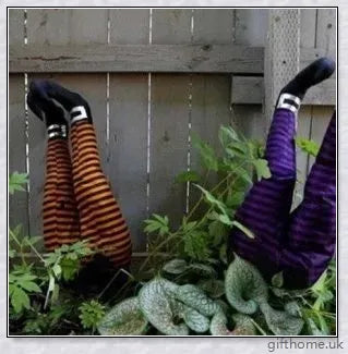 Animated witch legs in various colours, including purple, yellow, and black and white, kicking and moving to create a spooky Halloween display