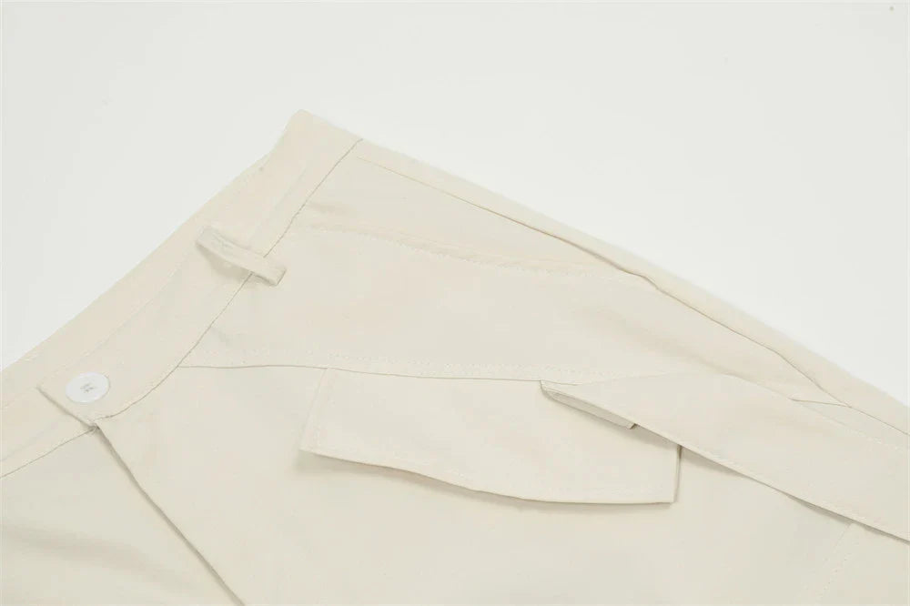 Stylish black pleated overalls with ribbon pockets, a versatile and refined menswear piece.