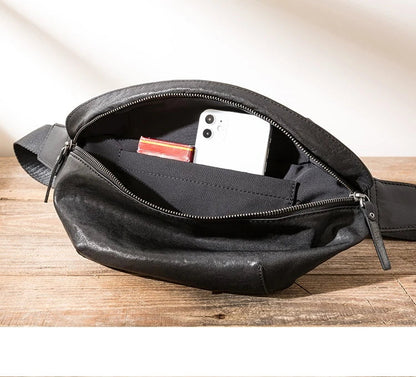 Premium cowhide messenger bag in black, featuring a spacious interior, adjustable shoulder strap, and sleek, minimalist design