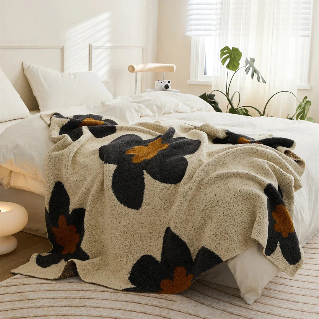 Cosy floral knitted throw blanket in red, featuring a chic bohemian design and luxurious microfibre fabric for maximum comfort and style.