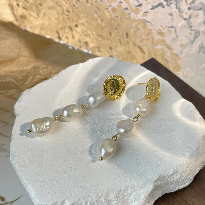 Elegant pearl and gold plated earrings with a long, eye-catching design