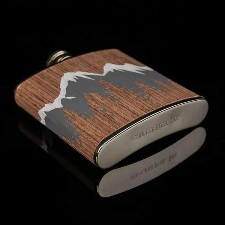 Stylish mountain-themed stainless steel and wood hip flask with optional glasses, perfect for outdoor adventures and social gatherings.