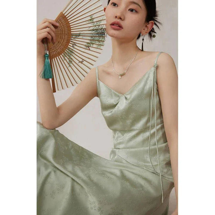 Elegant mint green midi dress with spaghetti straps, featuring a flattering slim fit and beautiful embroidery detailing