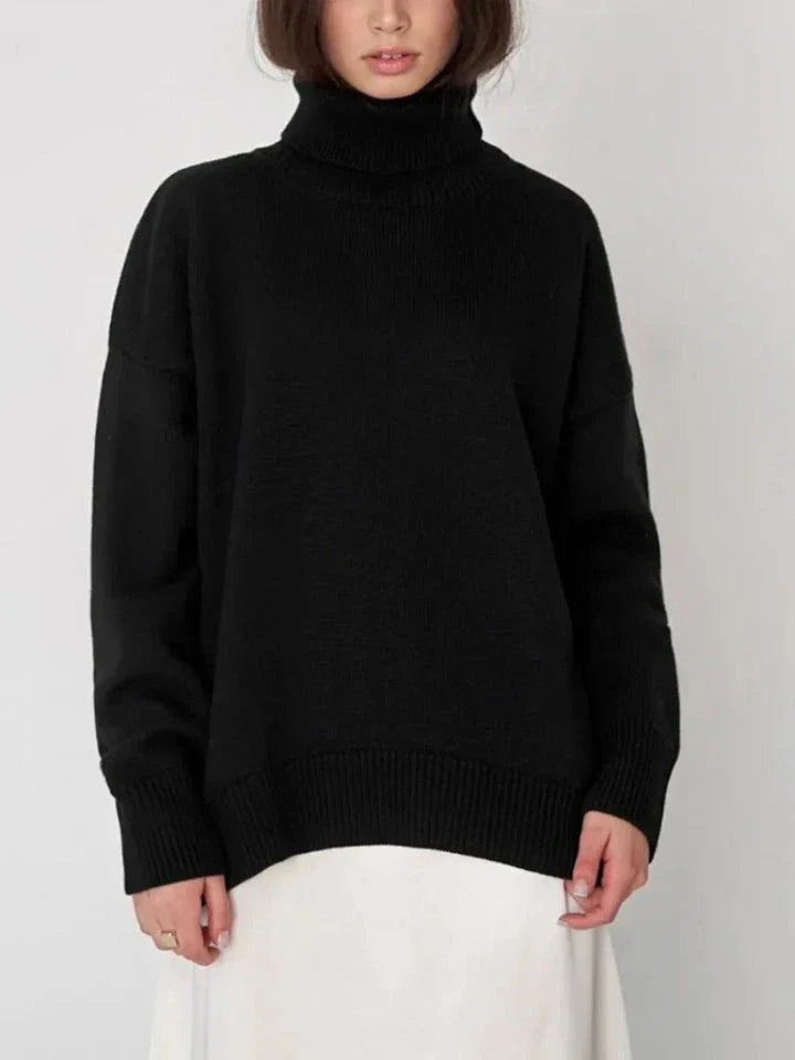 Cosy oversized knitted pullover in blue, featuring a classic turtleneck collar and drop-shoulder silhouette for maximum comfort and style.