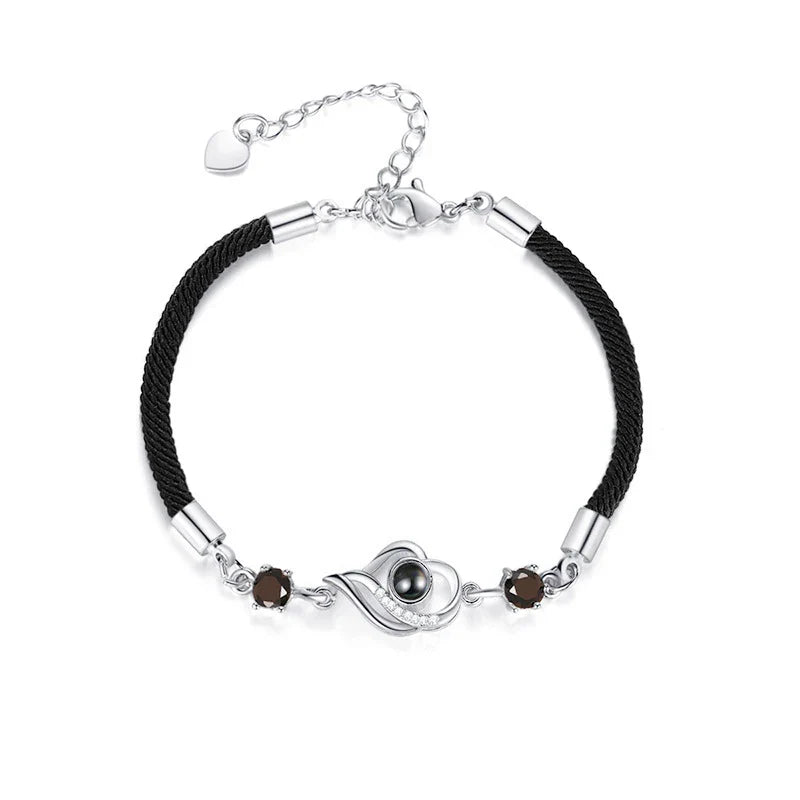 A rose gold or platinum plated copper charm bracelet featuring the phrase 'I Love You' inscribed in 100 languages.