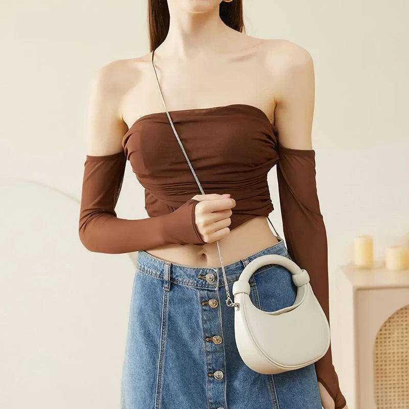 Elegant rose pink leather crescent-shaped crossbody bag with adjustable strap and zipper closure