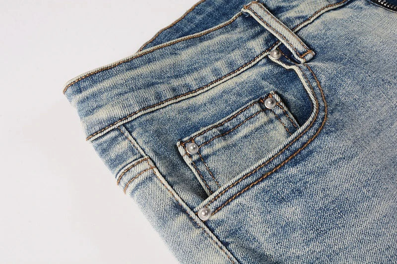 Stylish ripped denim jeans with a unique black and white patch design, perfect for British gentlemen