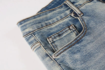 Stylish ripped denim jeans with a unique black and white patch design, perfect for British gentlemen