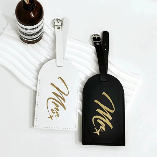 Stylish and practical Mr. and Mrs. Couples Luggage Tags in black and white colours, featuring a clear window for contact information and a secure strap for attaching to suitcases or travel bags.