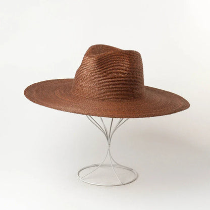 Premium outdoor sun protection straw hat in black, brown, and pinkish colours with a large brim and tie-dye pattern