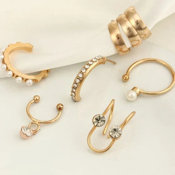 A set of 8 sophisticated gold-toned pearl stud earrings with unique, eye-catching designs