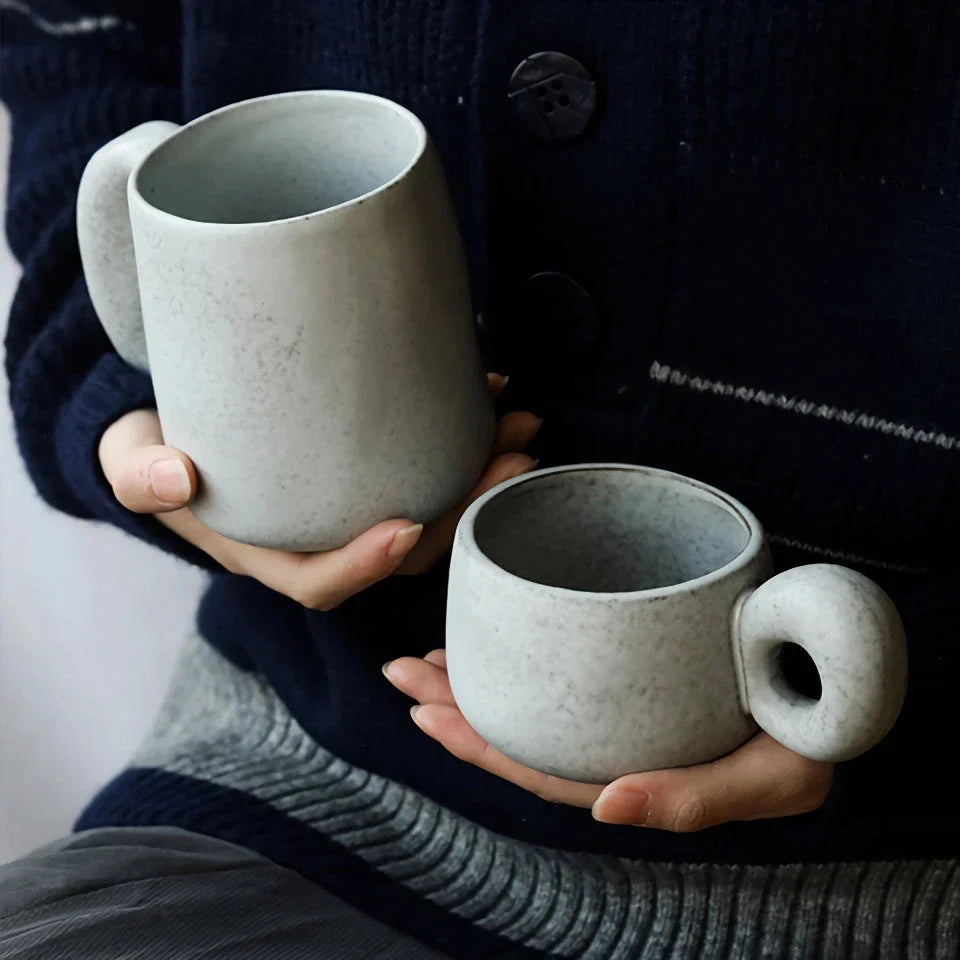 Handcrafted Japanese ceramic retro coffee mug in solid apricot or grey colour, featuring a comfortable handgrip design for enhanced daily beverage enjoyment.