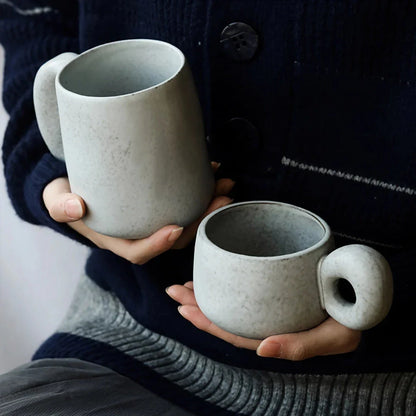 Handcrafted Japanese ceramic retro coffee mug in solid apricot or grey colour, featuring a comfortable handgrip design for enhanced daily beverage enjoyment.